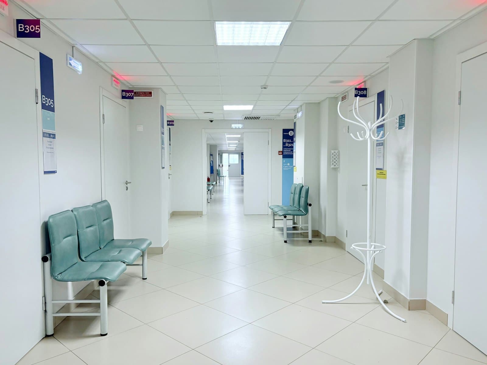 Clean clinic corridor with seating and white walls