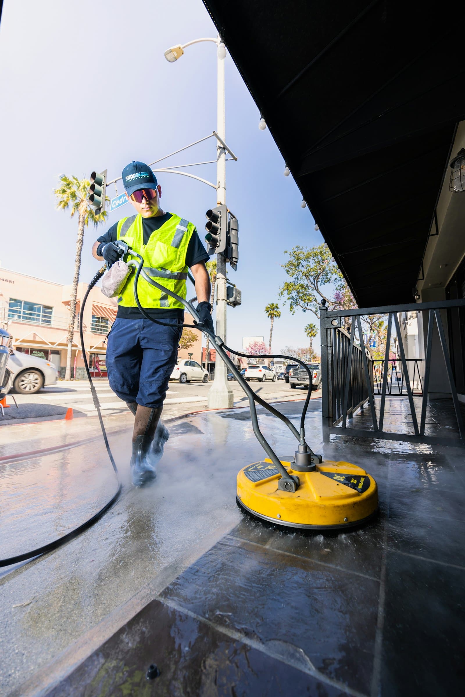 Operative in hi-vis pressure washing paving with a surface cleaner
