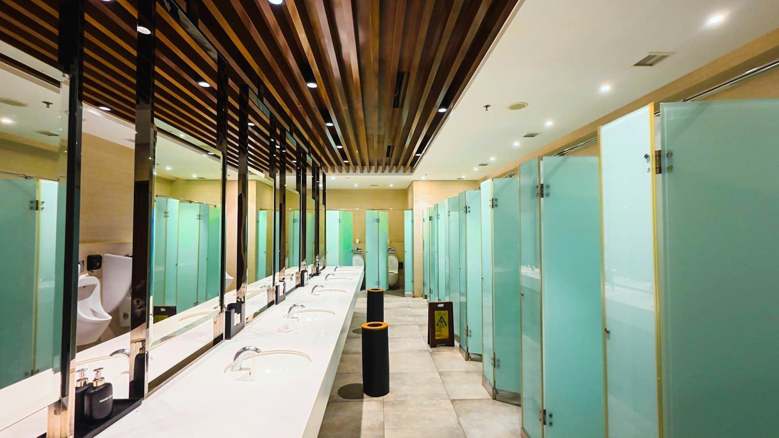 Clean modern public washroom with basins and frosted glass cubicles